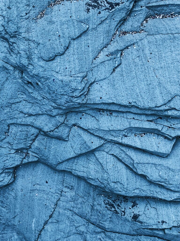 Blue-toned layered rock surface showcasing unique textures and formations.